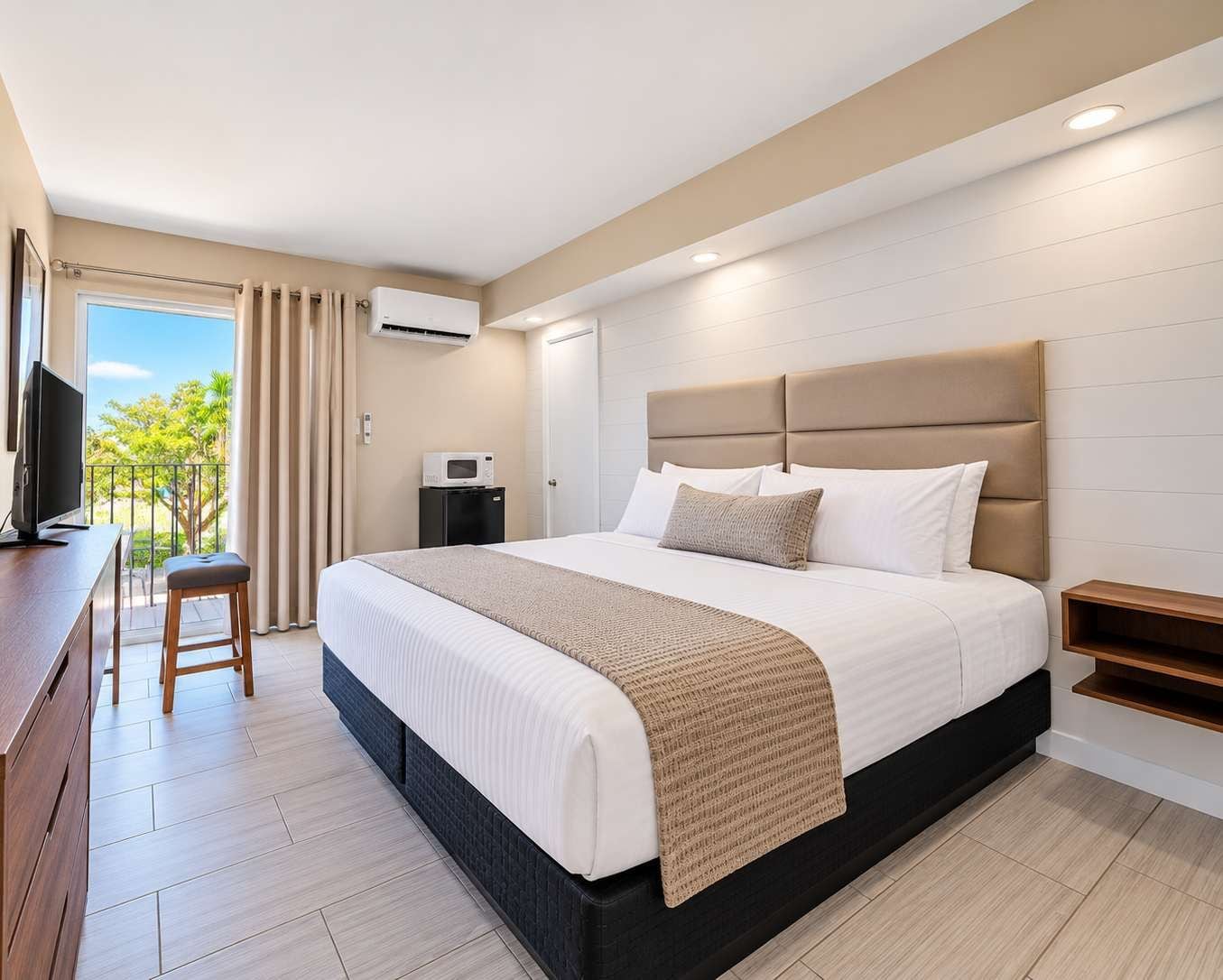 Een moderne hotelkamer met een groot bed, een bureau en uitzicht op de omgeving.