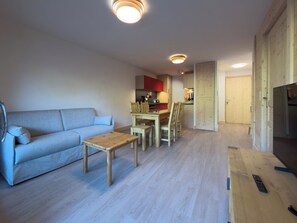 Una sala de estar con un sofá, una mesa de centro y un comedor con sillas y una mesa.