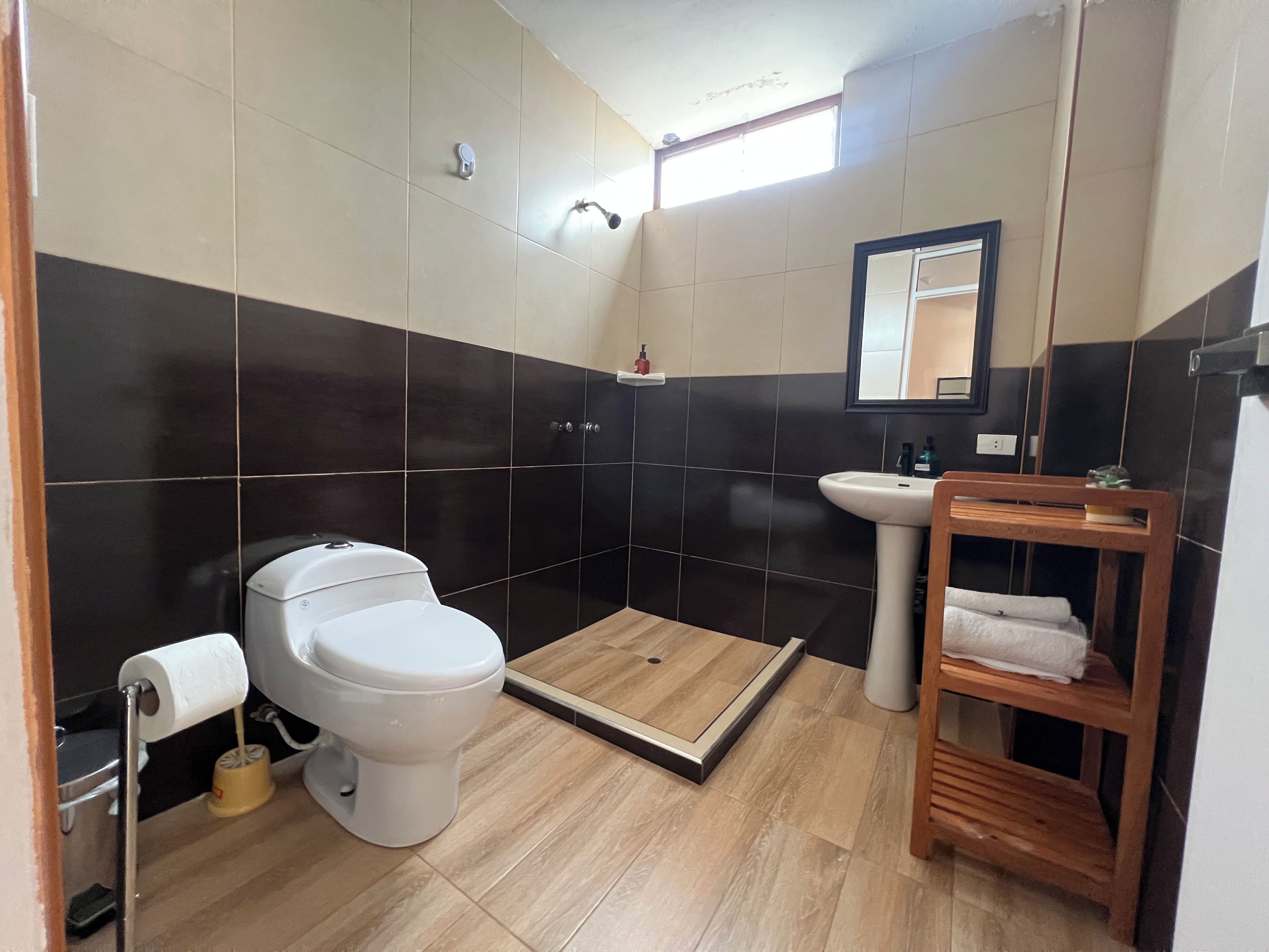 Une salle de bain comprenant des toilettes, un lavabo et un espace douche.