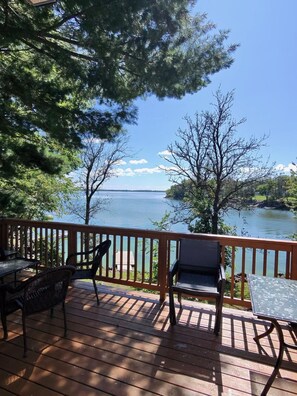 Eine Terrasse mit Gartenmöbeln mit Blick auf einen See.