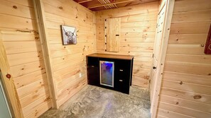Ein kleiner, abgeschlossener Raum mit Holzwänden, einer einzelnen Tür und einem kleinen Schreibtisch mit einem Computer.