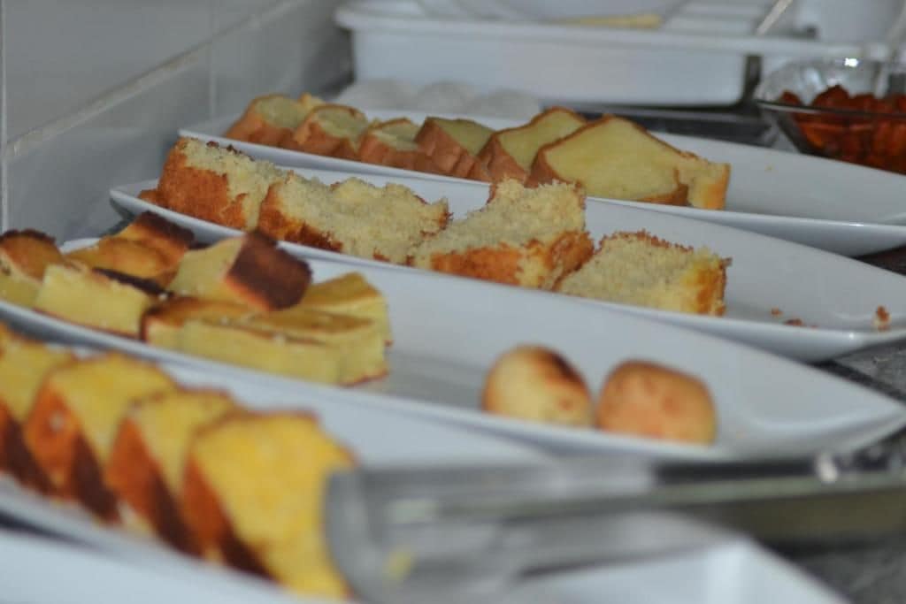 Un bufé con diversos alimentos en platos blancos.