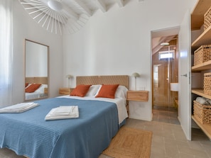 A bedroom with a large bed, bedside tables, a mirror, and a wardrobe. - Casa Azzurrina Mare (Campo nell'Elba)