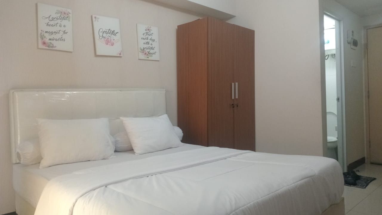 Ein Schlafzimmer mit einem Bett, einem Kleiderschrank und zwei Wandbildern.