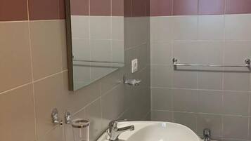 Un baño con lavamanos, espejo y retrete.