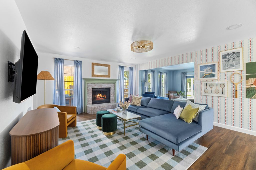 A living room with a fireplace, a blue sofa, a wooden coffee table, and a checkered rug.