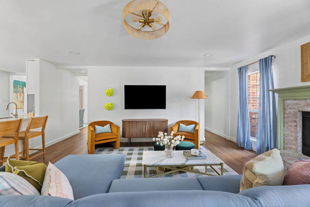 A living room with a sofa set, a coffee table, a television, and a fireplace.