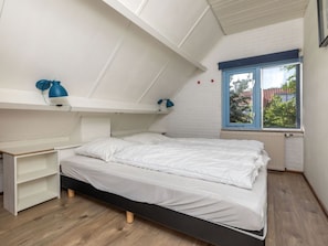 Ein Schlafzimmer mit Etagenbett, Schreibtisch und Fenster mit Blick nach draußen.