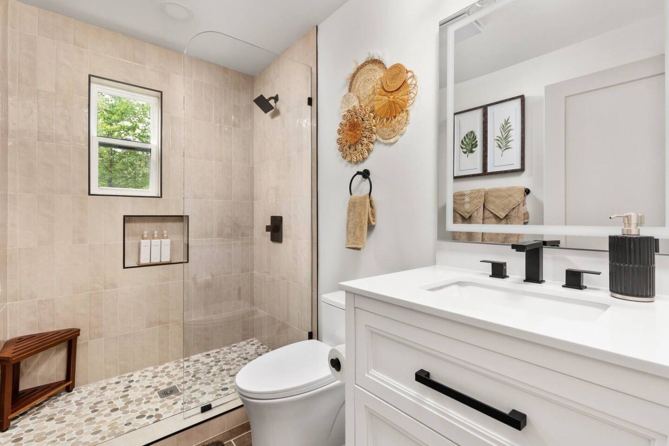 A modern bathroom with a shower, toilet, vanity, and a large mirror.