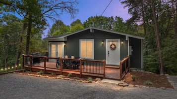 A cabin with a deck, a front door, and a small porch area.