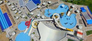 Ein Luftbild eines Wasserparks mit mehreren Pools, Rutschen und Liegestühlen.