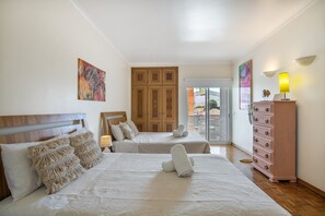 A hotel room with two beds, a wooden wardrobe, and a balcony with a view. - Apartment 'Areias Do Mar' (Albufeira)