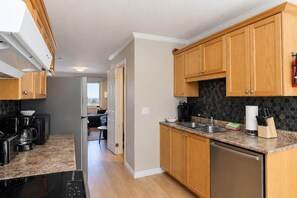 A modern kitchen with wooden cabinets, a granite countertop, and stainless steel appliances. - Shoreline Retreat-Beach front -Cottage 1 (Wasaga Beach)