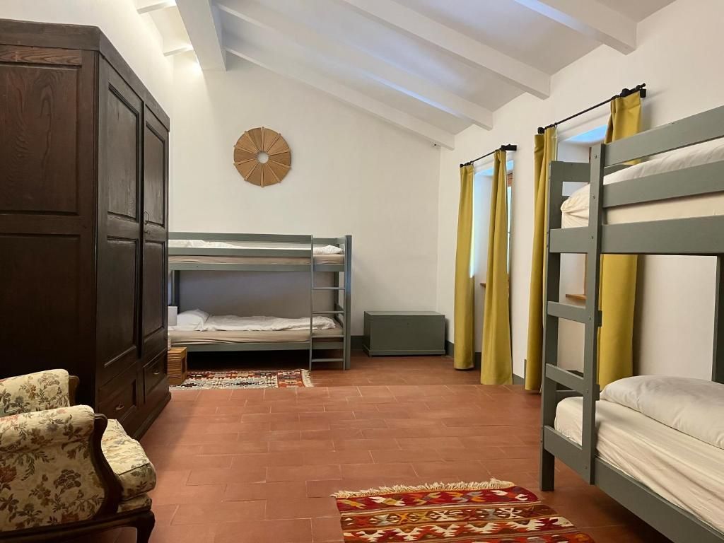 Una habitación con literas, un armario, un reloj y una alfombra estampada.