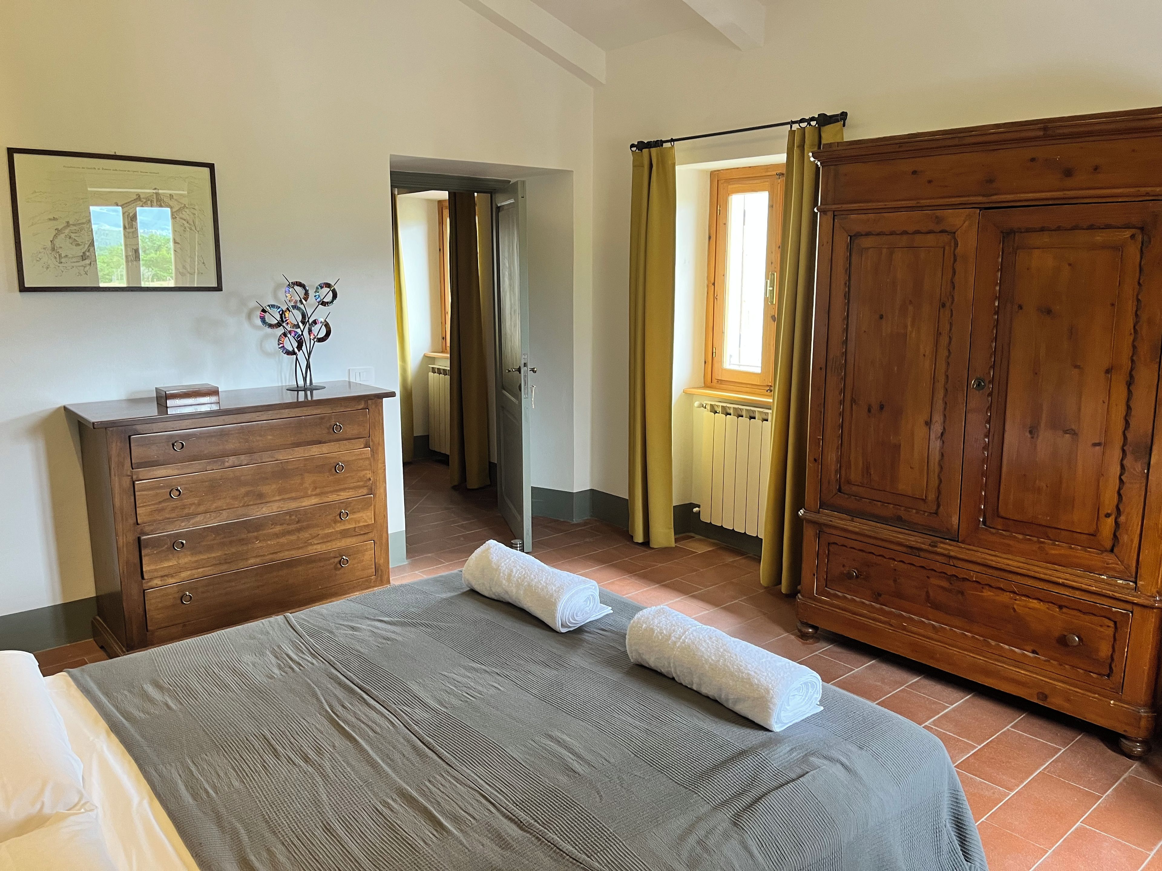 Un dormitorio con cama, cómoda, armario y un cuadro en la pared.