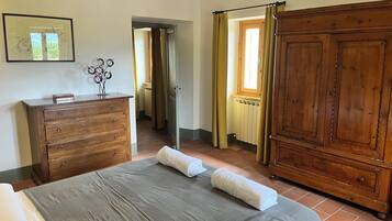 Un dormitorio con cama, cómoda, armario y un cuadro en la pared.