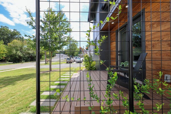 A modern building with a wooden deck and a metal fence.