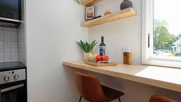 A kitchen with a built-in oven, a wooden countertop, and a window with a view of the outside.