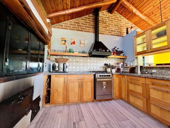 Eine Küche mit Holzausstattung, einem Gasherd, einem Backofen und einer Mikrowelle.