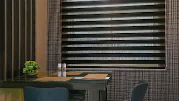 A dining area with a modern table, chairs, and a decorative light fixture.