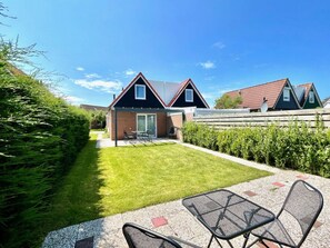 A residential area with a house featuring a patio with outdoor furniture. - Holiday Home With 2 Bedrooms (Oostkapelle)