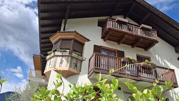 Un bâtiment doté de nombreux balcons, d’une tourelle d’angle ornée d’éléments décoratifs, et un ciel dégagé en arrière-plan.