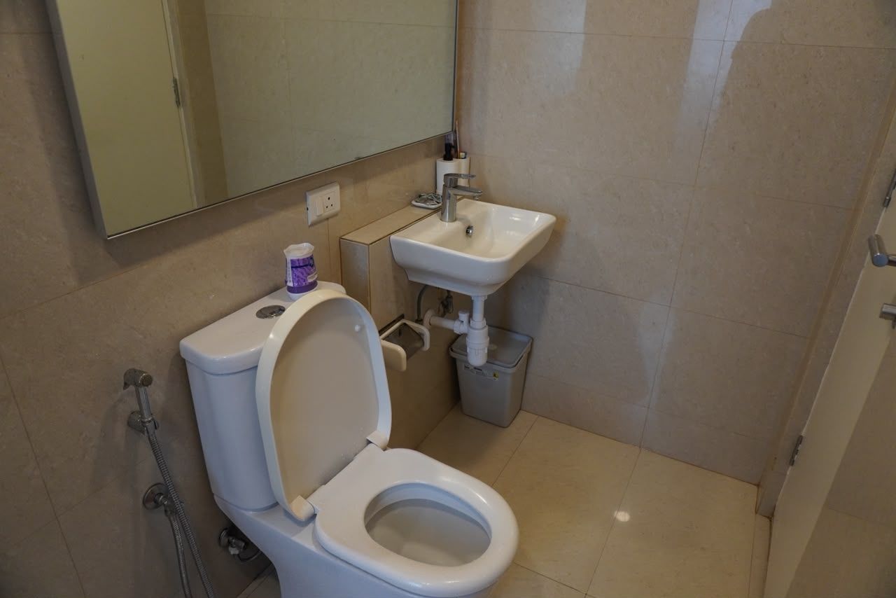 A bathroom with a toilet, sink, and shower.