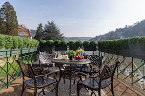A terrace with a round table, four chairs, and a view of the countryside. - Signature Residences - River View (Heidelberg)