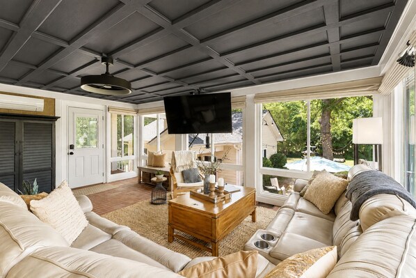 A spacious living room with a large sofa, a coffee table, and a television. - Owens Retreat - Private Home on 2 Acres (Greer)