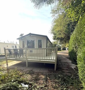 Une maison mobile dotée d’un porche et d’une petite terrasse.