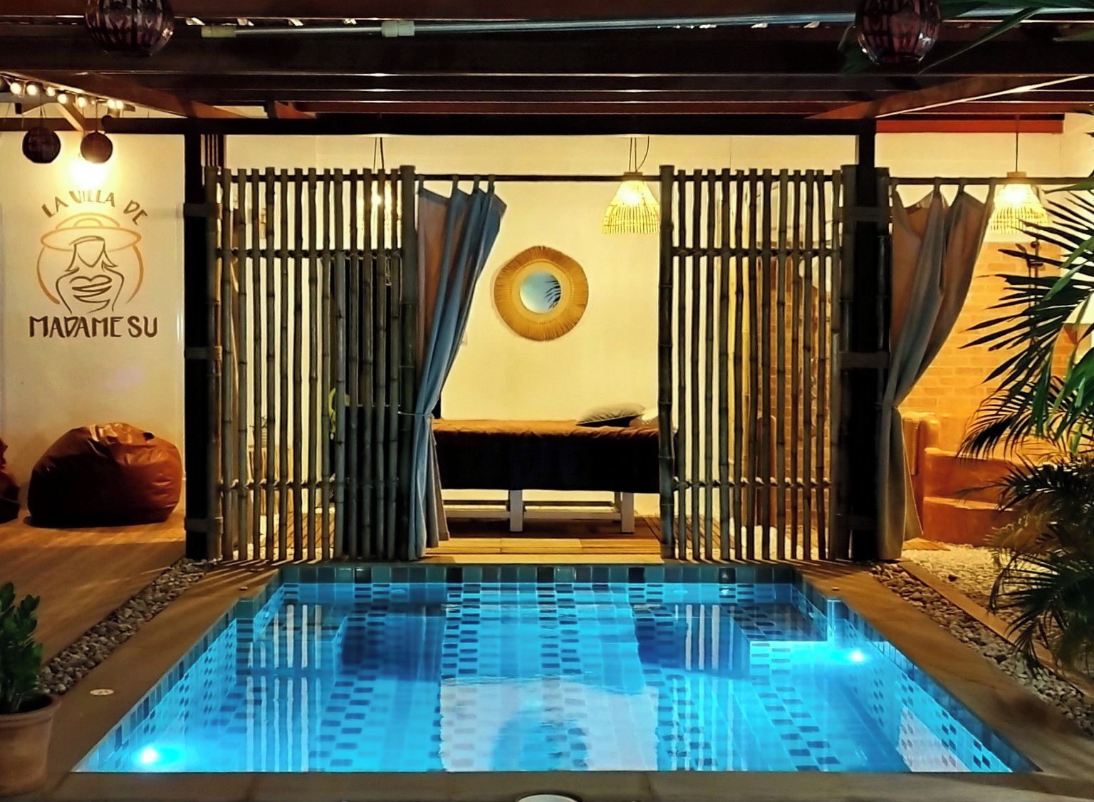 Ein Wellnessbereich mit Massageliege, Pool und einer Wand mit einem Logo.