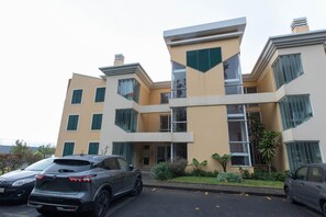 Un edificio de varios pisos con un diseño arquitectónico moderno, que cuenta con un atrio central y amplios ventanales.