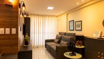Una sala moderna con un sofá, una mesita, un ventilador y una lámpara decorativa.
