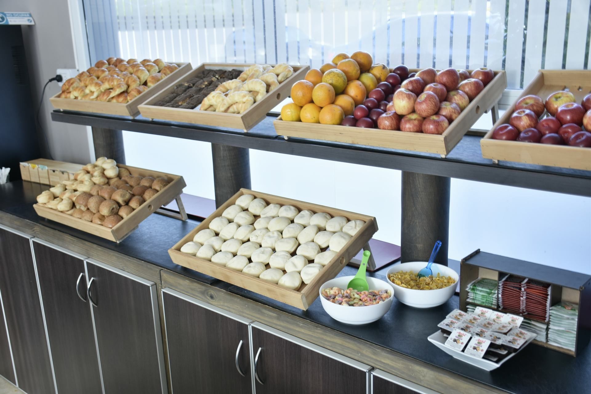 Un bufé con diversos alimentos, incluyendo pasteles, frutas y pan.