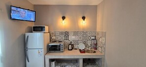 A compact kitchenette with a microwave, toaster, and refrigerator. - Hotel Marítimo (Villa Gesell)