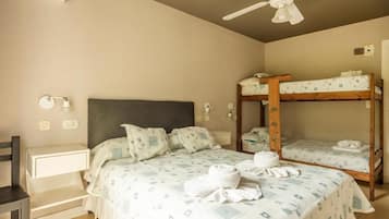 A bedroom with a single bed, a bunk bed, a desk, and a chair.