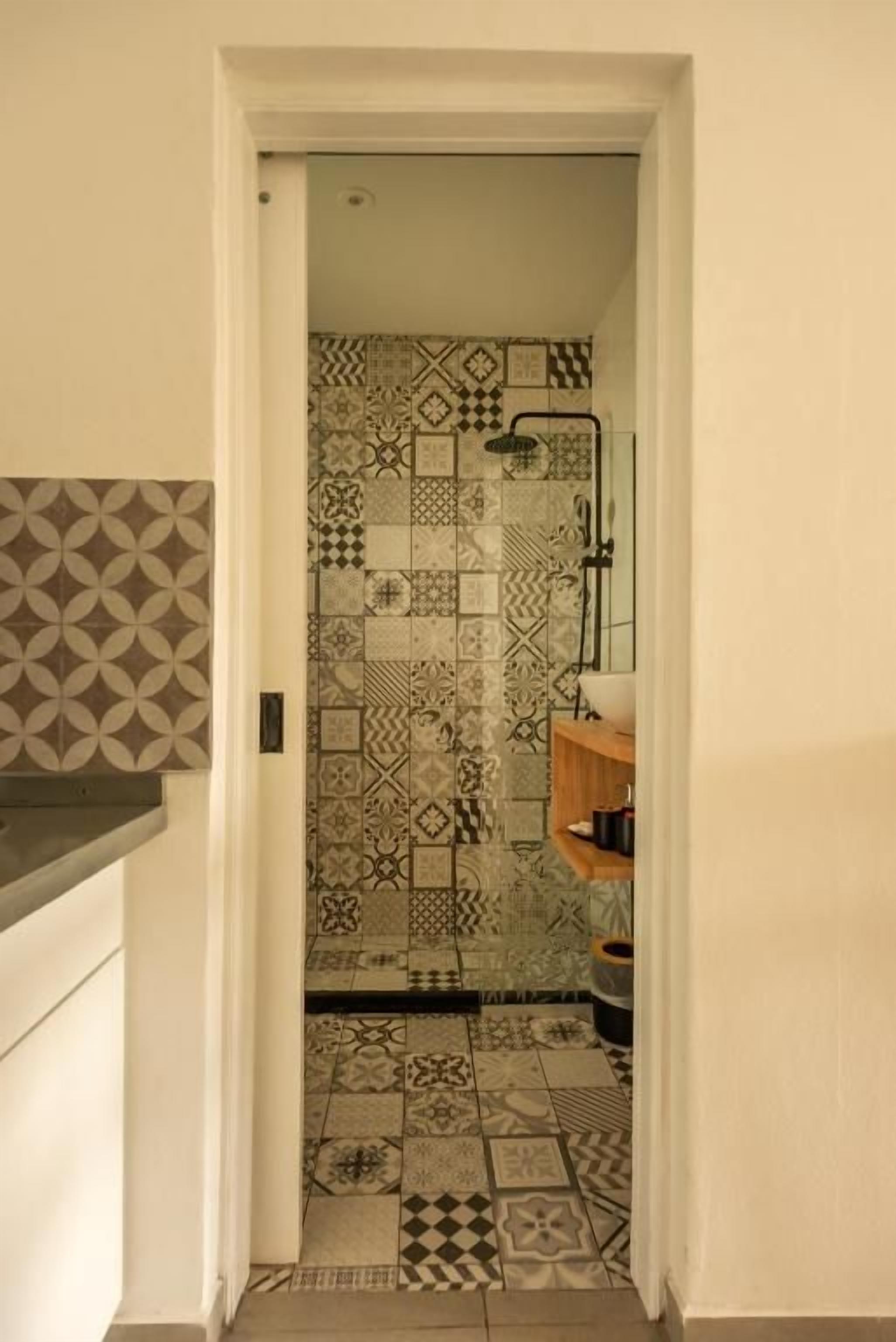 Une salle de bain avec une douche et un sol carrelé.