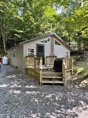 A single-story cabin with a front porch, a chimney, and a door. - Cozy Old Forge Cabin Minutes to Village, Lakes & Snowmobile Trails (Old Forge)