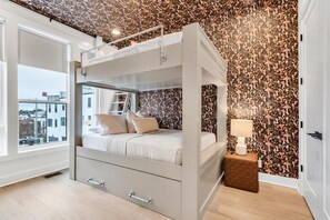 Ein modernes Schlafzimmer mit Etagenbett, Blick auf die Stadt und strukturierter Tapete.