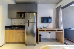 A compact kitchenette with a refrigerator, microwave, and sink. - On Augusta by Bhomy (São Paulo)