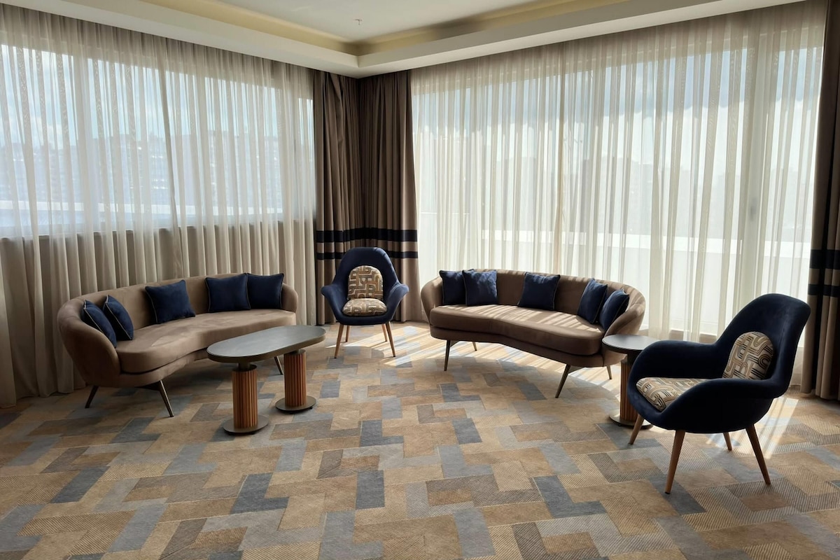 A modern living room with a sectional sofa, two armchairs, and a coffee table.