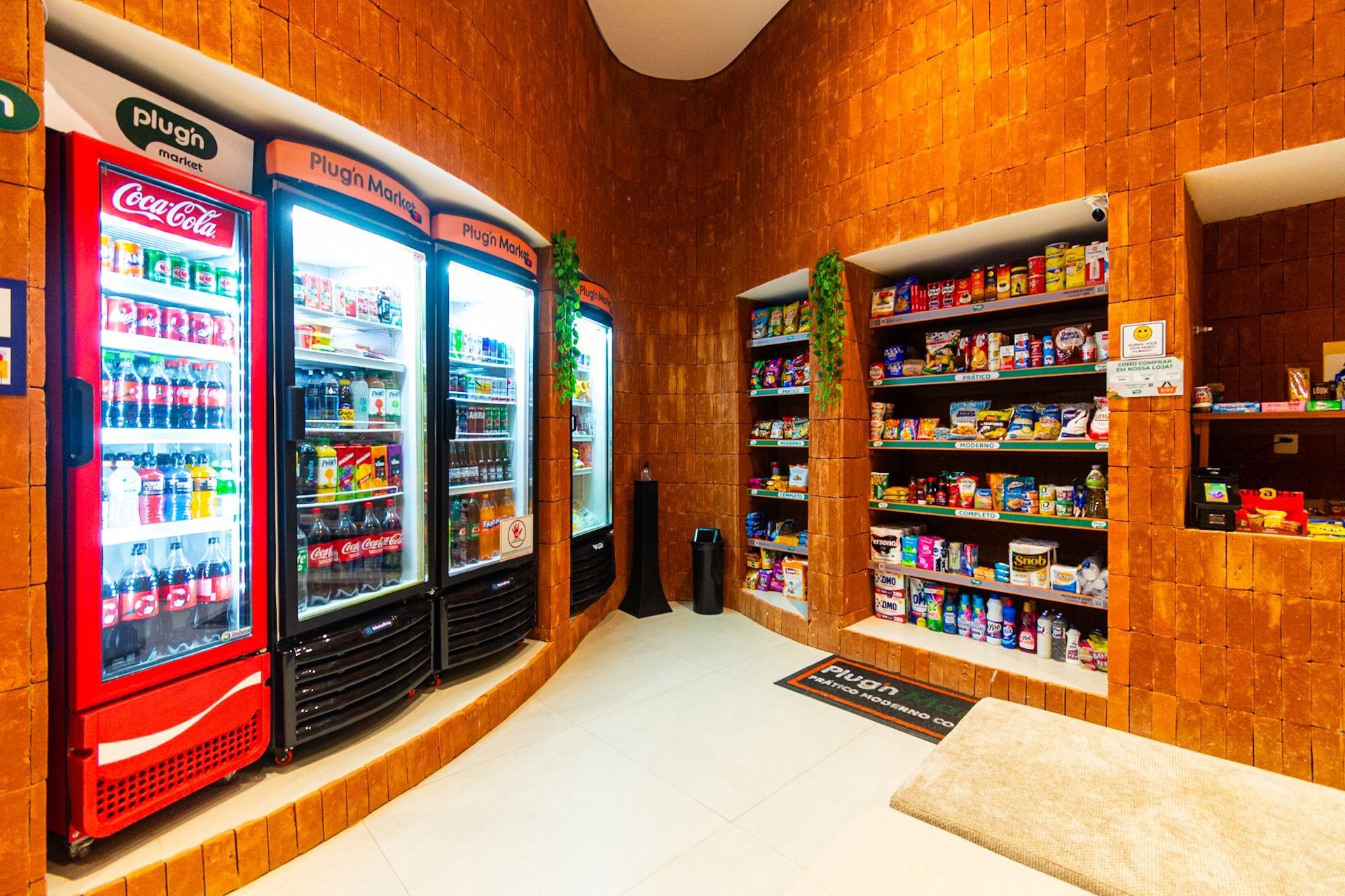 Eine Snackbar mit Coca-Cola- und anderen Getränkeautomaten, Regalen voller Snacks und einem Schild, das den Standort angibt.