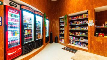 Eine Snackbar mit Coca-Cola- und anderen Getränkeautomaten, Regalen voller Snacks und einem Schild, das den Standort angibt.