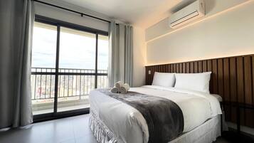 Een hotelkamer met een groot bed, uitzicht op de stad en een airconditioning.