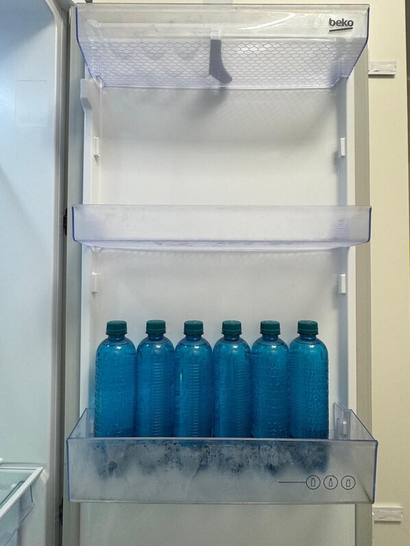 Geladeira com dispensador de água na parte superior e compartimento para congelador abaixo.