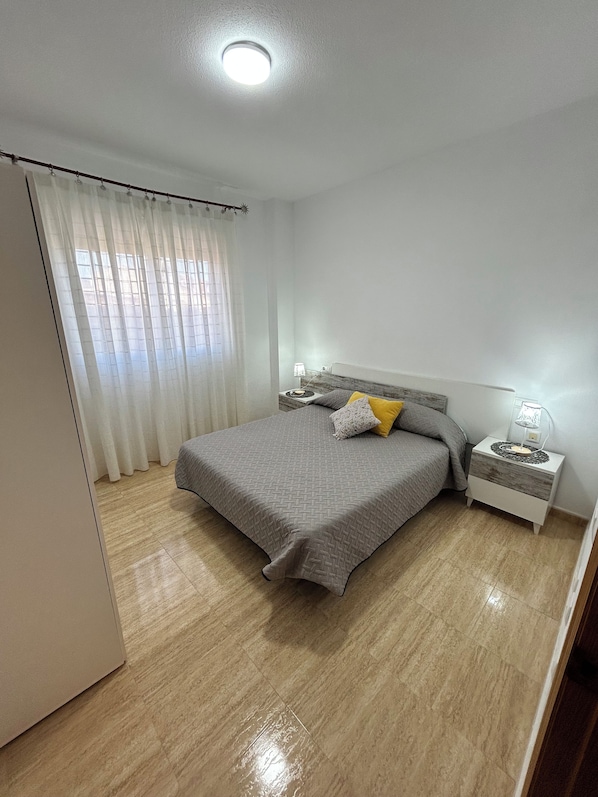 A bedroom with a bed, nightstands, a lamp, and a window with curtains. - Spacious 4-bedroom house with a large terrace. (El Algar)