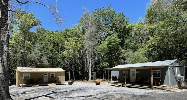 A campground with two cabins, outdoor seating, and a covered area.