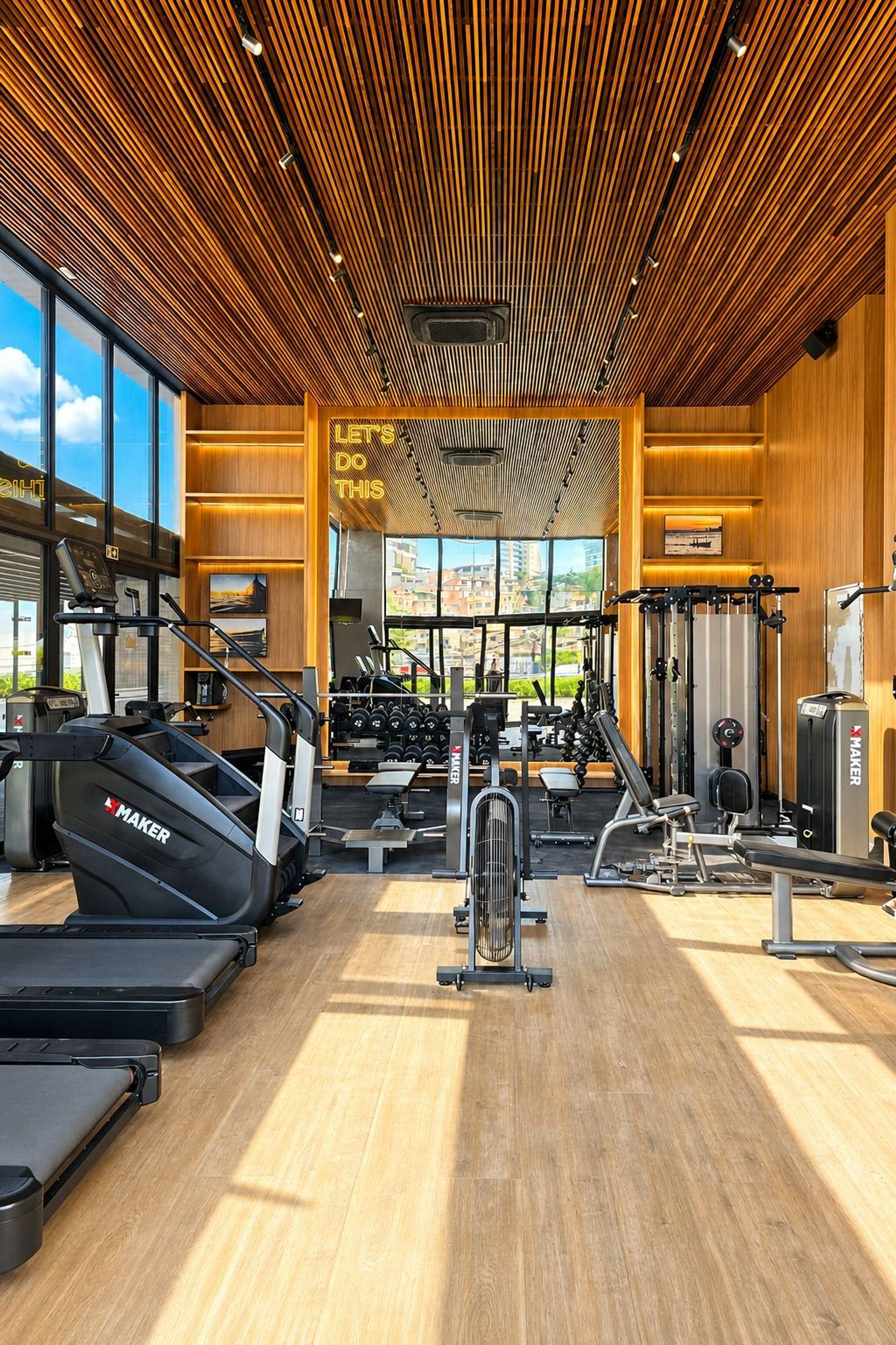 A gym with treadmills, weight machines, and a motivational sign.
