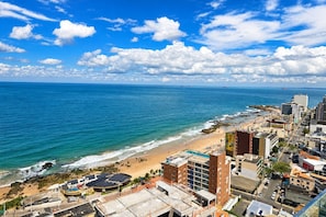 Un paisaje urbano costero con playa, edificios y cielo despejado.