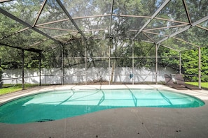 Une piscine couverte avec vue sur les arbres et un mur blanc en arrière-plan.